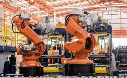 Image of two robotic arms working in a factory