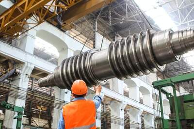 Photograph of man directing a crane with sensors to install a large industrial part
